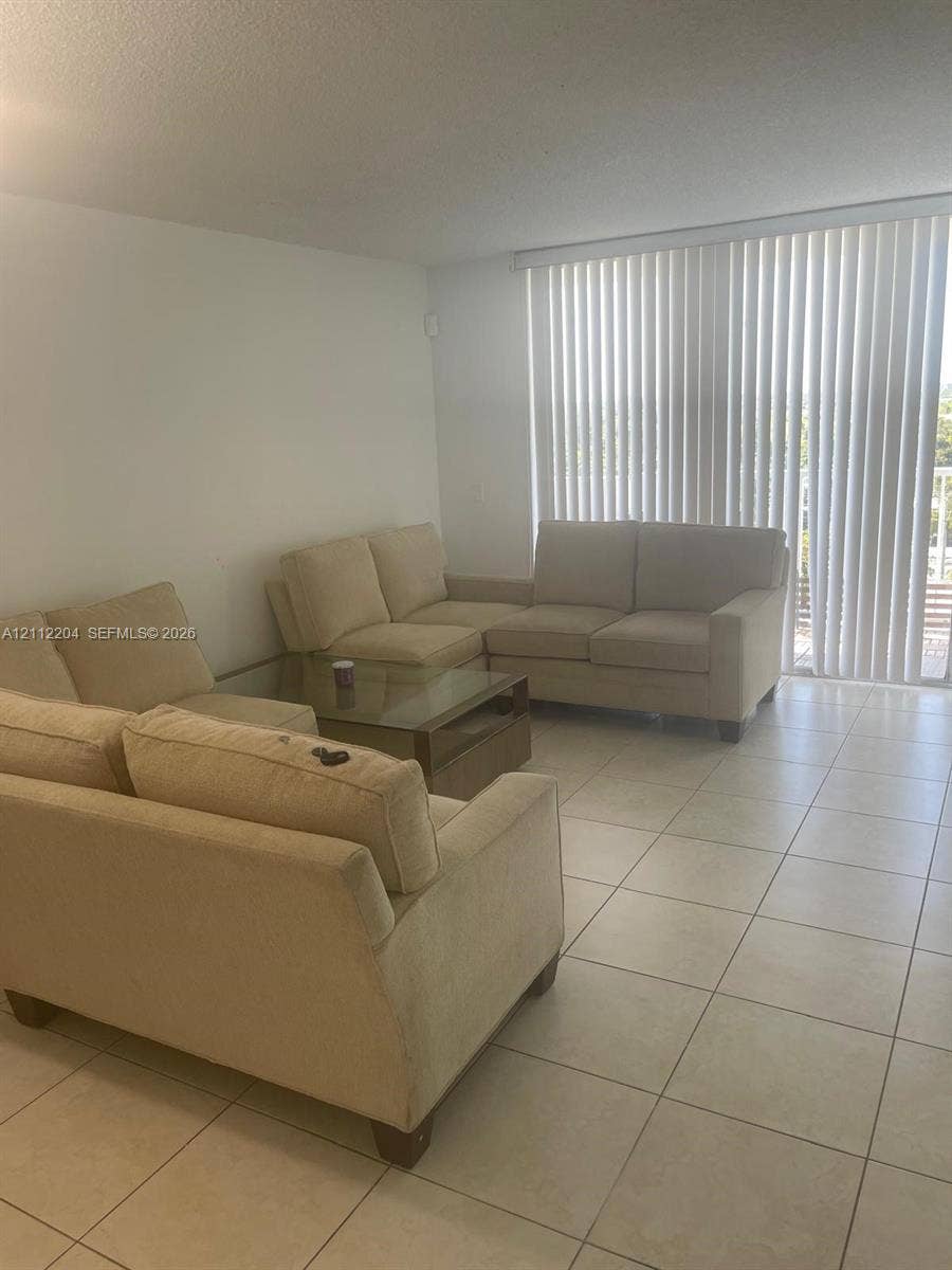 2020 NE 135th Street, #910, North Miami, North Miami, FL 33181 Neutral-toned ceramic tile flooring and floor-to-ceiling vertical blinds