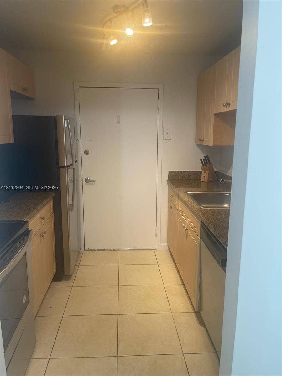 2020 NE 135th Street, #910, North Miami, North Miami, FL 33181 Kitchen featuring light-finish cabinetry, stone-surface countertops, tile flooring, stainless steel appliances, and multi-bulb track lighting
