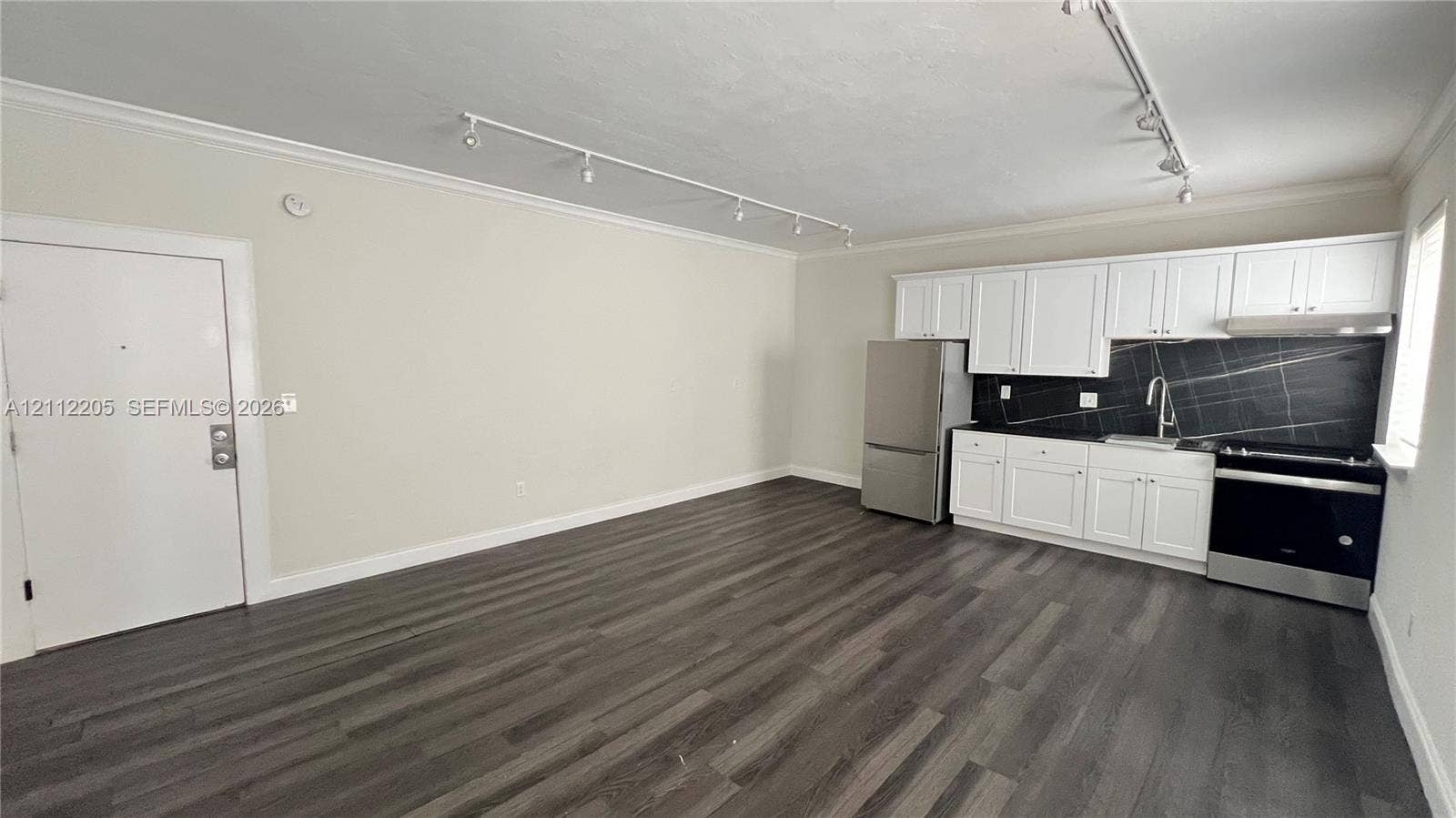 1115 Euclid Avenue, #5, Miami Beach, Miami Beach, FL 33139 Kitchen featuring white shaker-style cabinetry, a dark stone backsplash, stainless steel appliances, wood-finish flooring, and adjustable track lighting