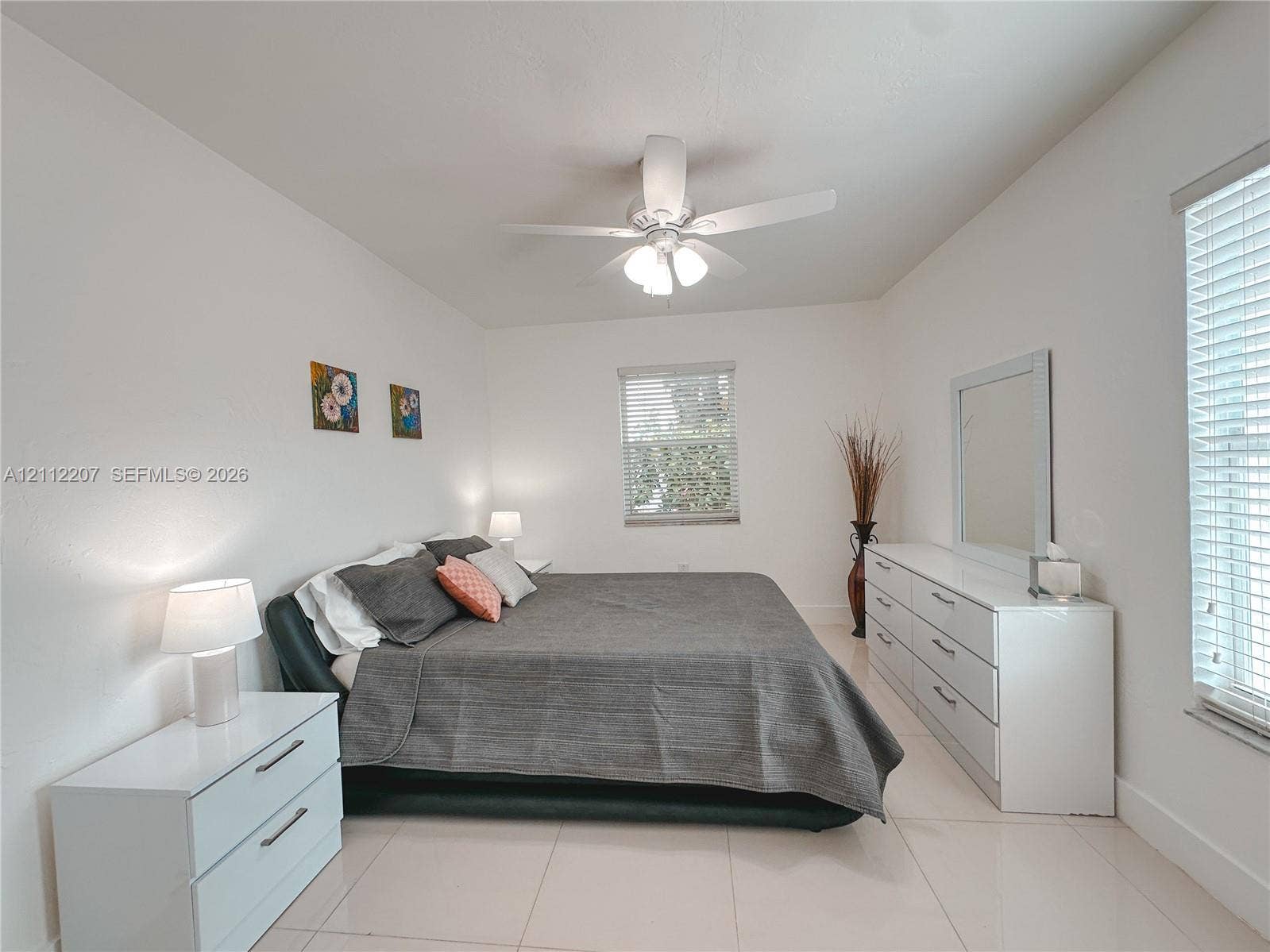 525 SW 67th Avenue, Miami, Miami, FL 33144 Spacious room featuring neutral tile flooring, a multi-blade ceiling fan with integrated lighting, and multiple windows fitted with horizontal blinds