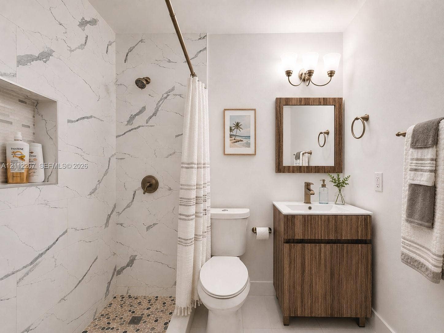 525 SW 67th Avenue, Miami, Miami, FL 33144 Bathroom featuring a walk-in shower with stone-patterned wall tile, a recessed storage niche, a pebble-finish floor, a wood-finish vanity with a rectangular sink, and a three-light wall-mounted fixture