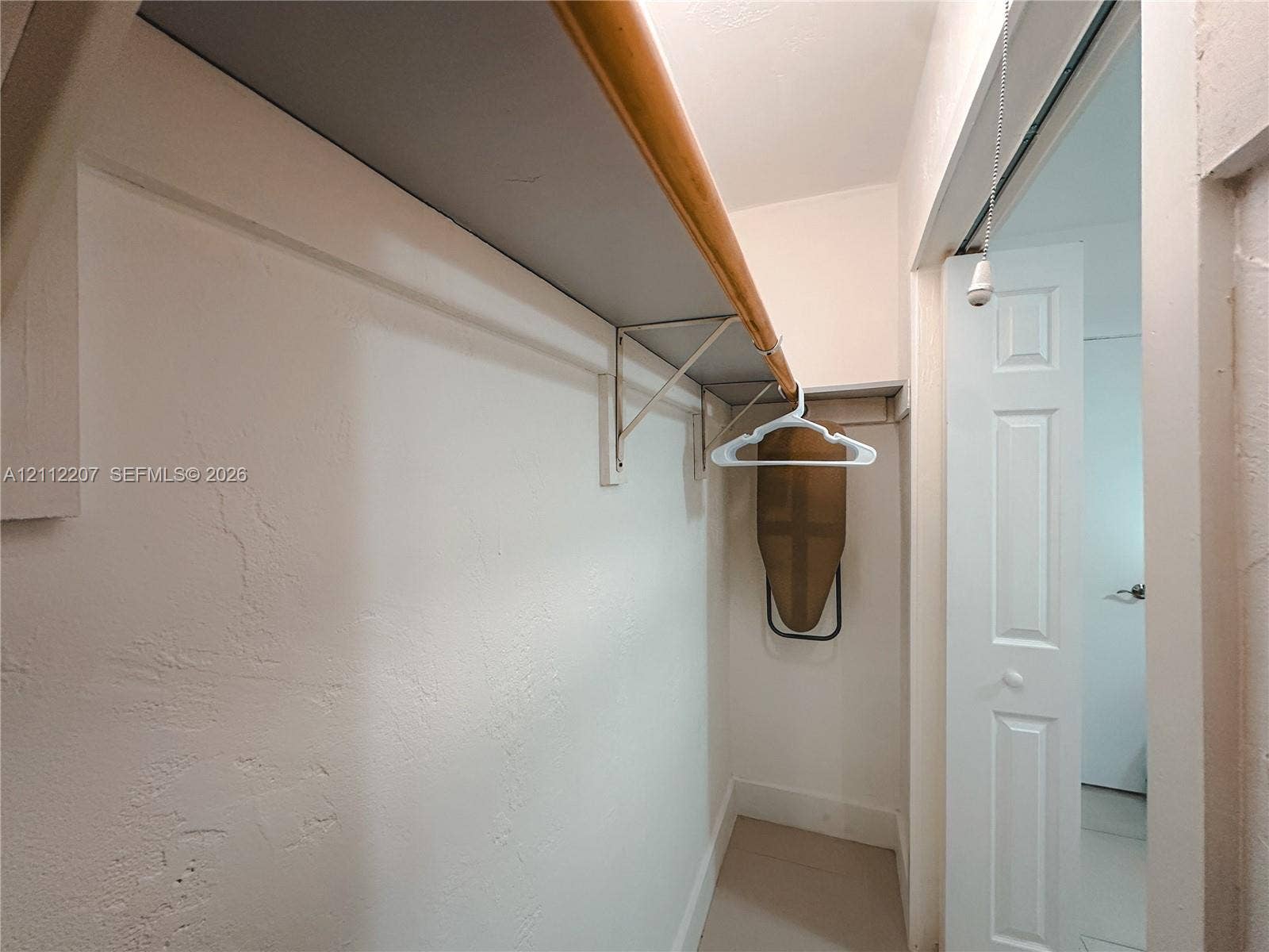 525 SW 67th Avenue, Miami, Miami, FL 33144 Reach-in closet featuring built-in shelving with wood trim and a bifold door