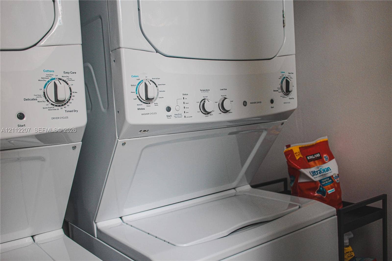 525 SW 67th Avenue, Miami, Miami, FL 33144 Stacked white laundry appliance unit featuring a top-load washer and front-control drying interface