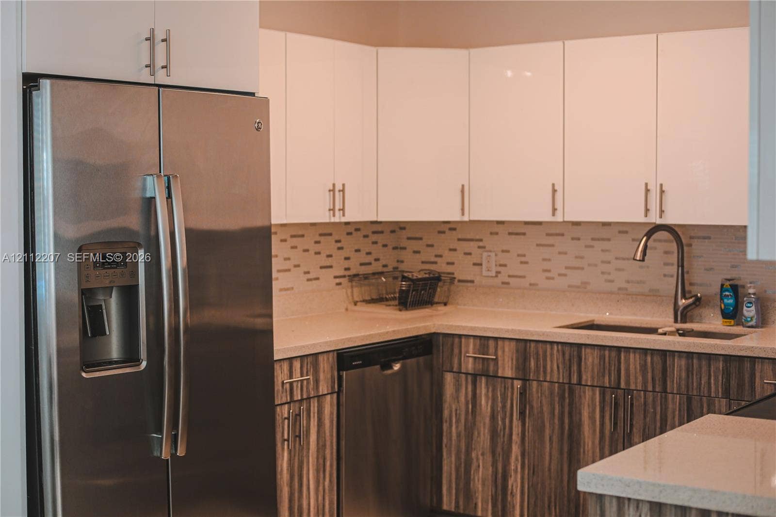 525 SW 67th Avenue, Miami, Miami, FL 33144 Kitchen featuring white upper cabinetry, wood-finish lower cabinetry, stone-surface countertops, a stainless steel refrigerator and dishwasher, and a tile backsplash