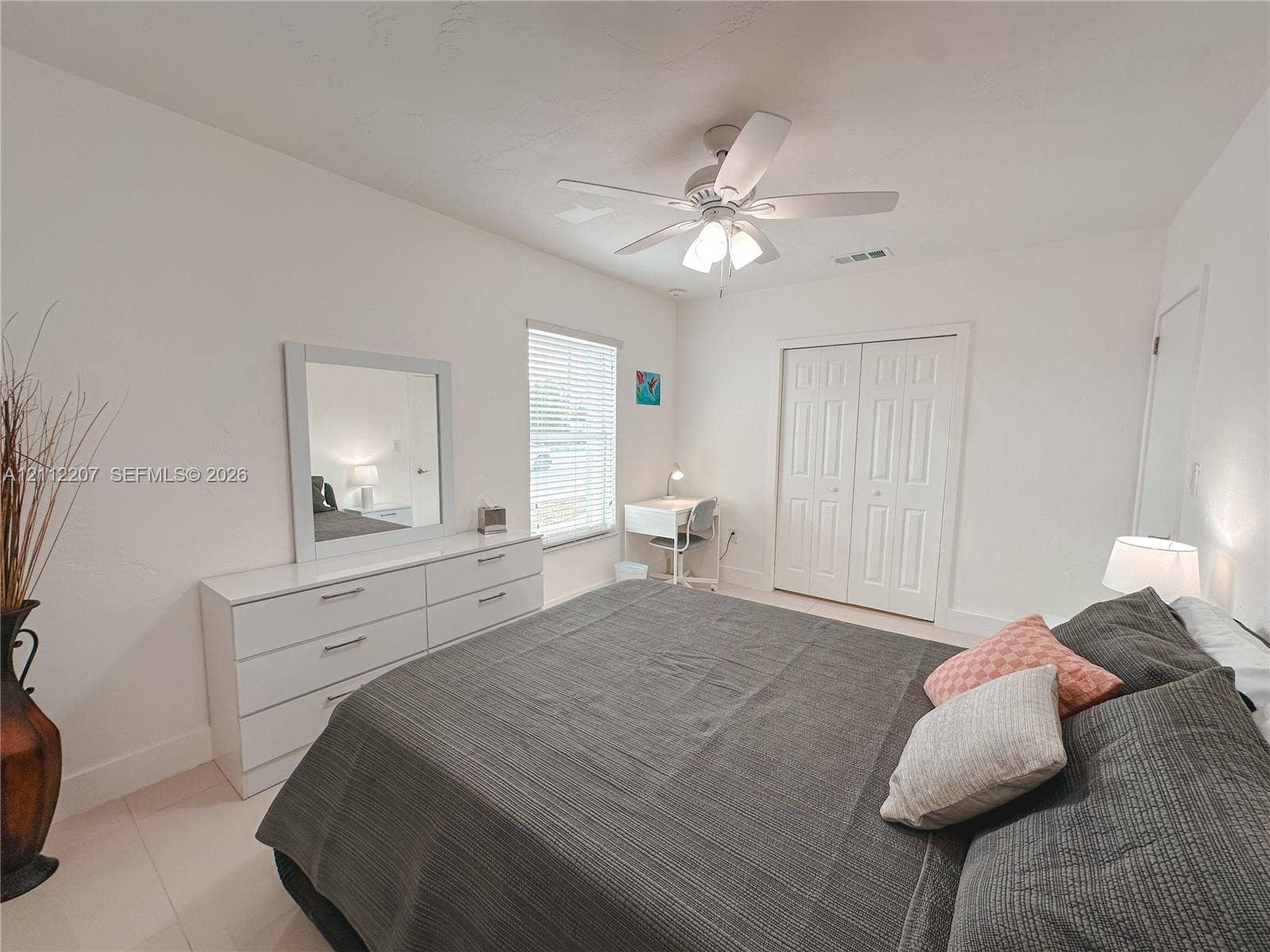 525 SW 67th Avenue, Miami, Miami, FL 33144 Neutral interior featuring white walls, window with horizontal blinds, ceiling fan with integrated lighting, and dual-panel closet doors