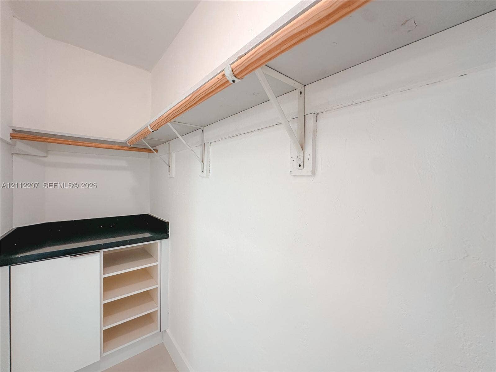 525 SW 67th Avenue, Miami, Miami, FL 33144 Built-in cabinetry with integrated open shelving, solid surface countertop, and wall-mounted wood-finish clothing rods with metal supports