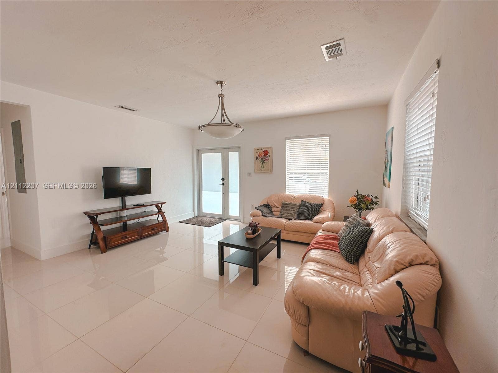 525 SW 67th Avenue, Miami, Miami, FL 33144 Neutral-toned tile flooring, semi-flush mount bowl lighting, and glass-paneled exterior doors with horizontal blinds
