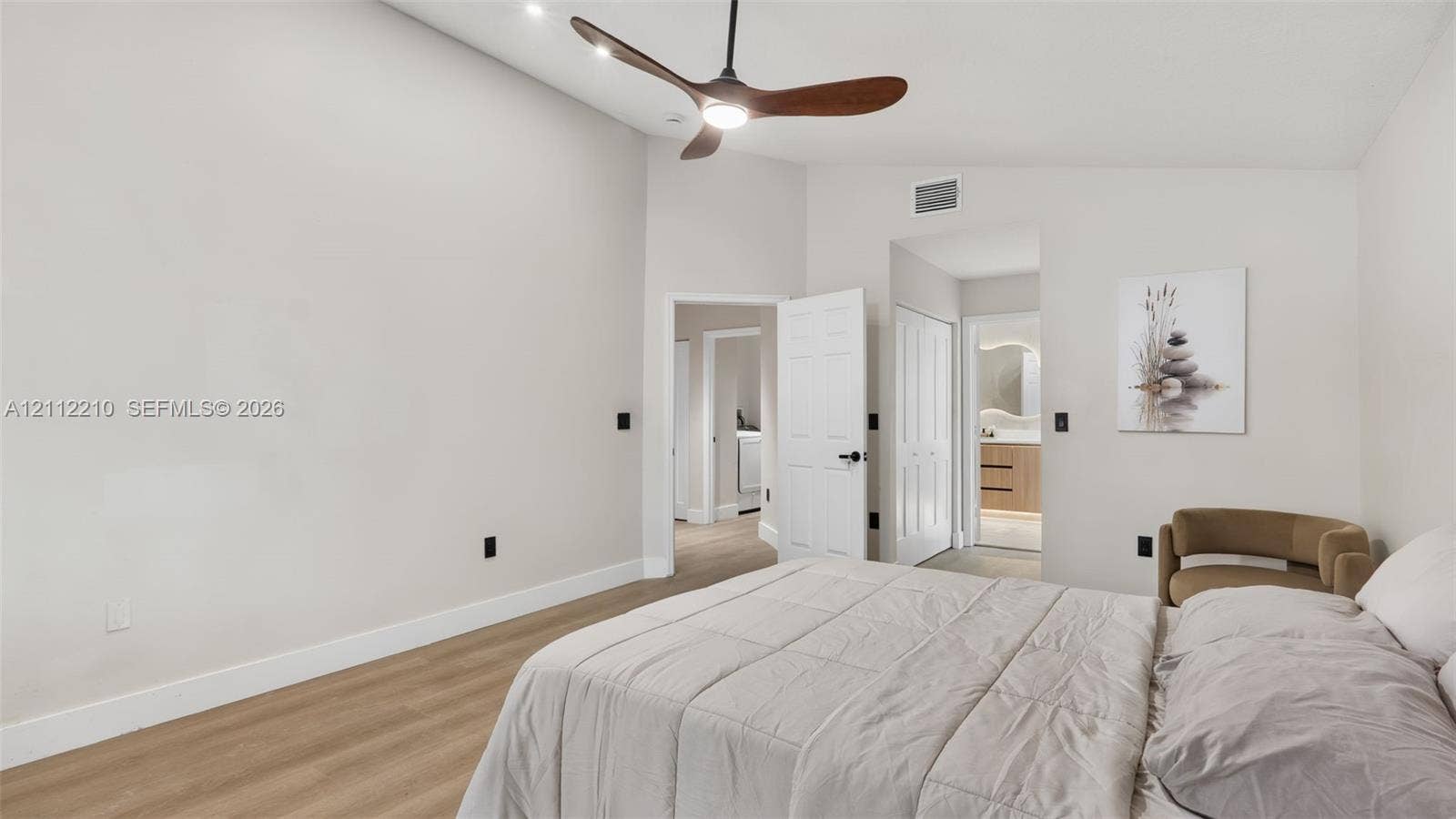 Vaulted ceilings, wood-finish flooring, and a modern ceiling fan with integrated lighting
