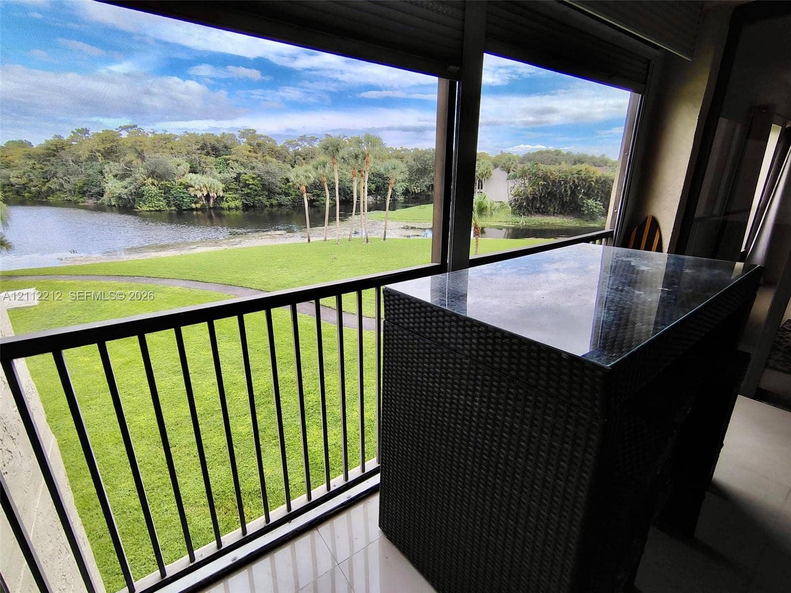 2900 NW 42nd Avenue, #304A, Coconut Creek, Coconut Creek, FL 33066 Screened balcony featuring metal railings, tiled flooring, and a sliding glass door enclosure