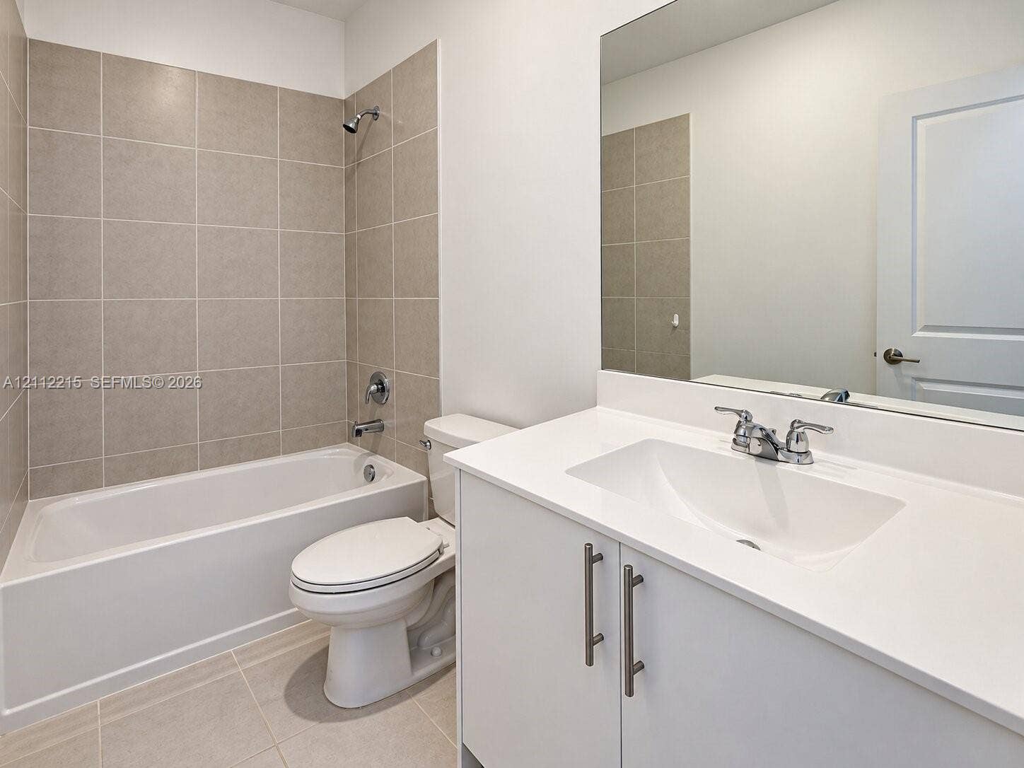 1161 SE 1 Street, #0, Florida City, Florida City, FL 33034 Bathroom featuring a white vanity cabinet with quartz countertop, integrated sink, polished chrome faucet, large wall-mounted mirror, and a tub-shower combination with floor-to-ceiling tile surround