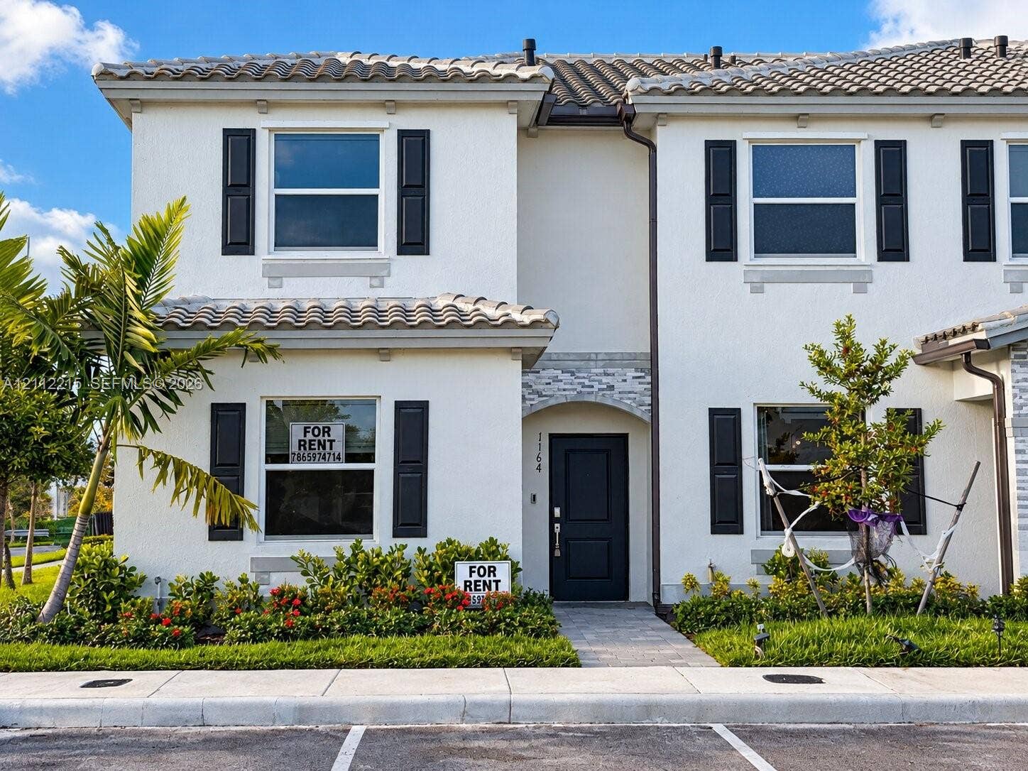 1161 SE 1 Street, #0, Florida City, Florida City, FL 33034 Two-story stucco exterior featuring a tiled roof, decorative shutter accents, stone-veneered entryway arch, and paved walkway