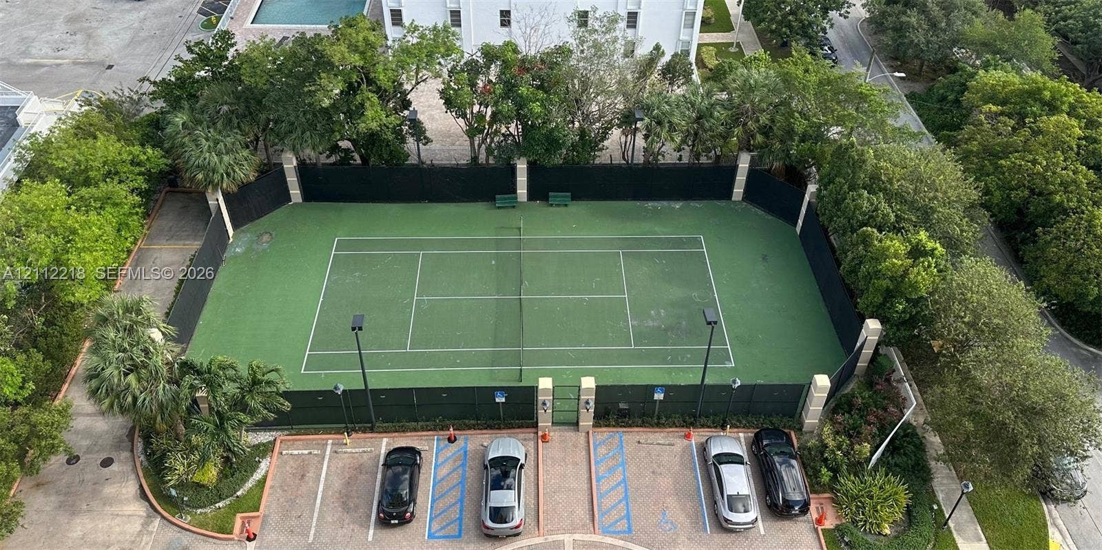 2475 Brickell Avenue, #1905, Miami, Miami, FL 33129 Private tennis court featuring a fenced perimeter, outdoor lighting, and paved parking area