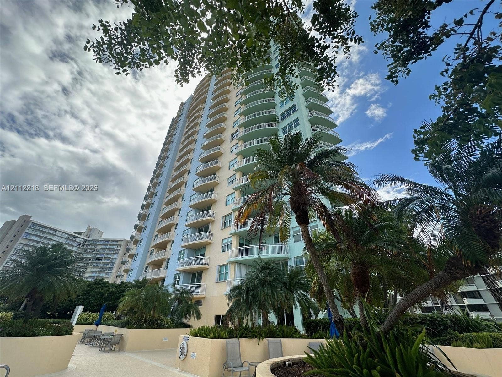 2475 Brickell Avenue, #1905, Miami, Miami, FL 33129 High-rise architectural exterior featuring tiered balconies, a smooth stucco facade, and an integrated paved pool deck with mature landscaping