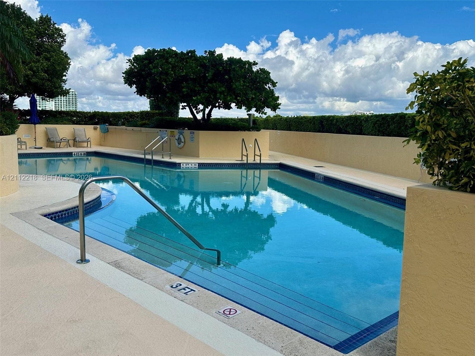 2475 Brickell Avenue, #1905, Miami, Miami, FL 33129 Swimming pool featuring integrated stairs, metal handrails, a perimeter tiled edge, and a surrounding concrete deck
