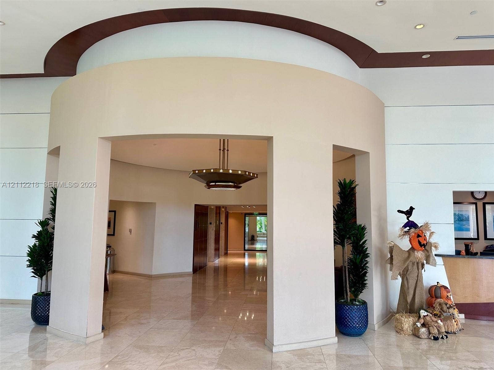 2475 Brickell Avenue, #1905, Miami, Miami, FL 33129 Curved architectural entryway featuring stone tile flooring, recessed ceiling design, and a tiered metal chandelier