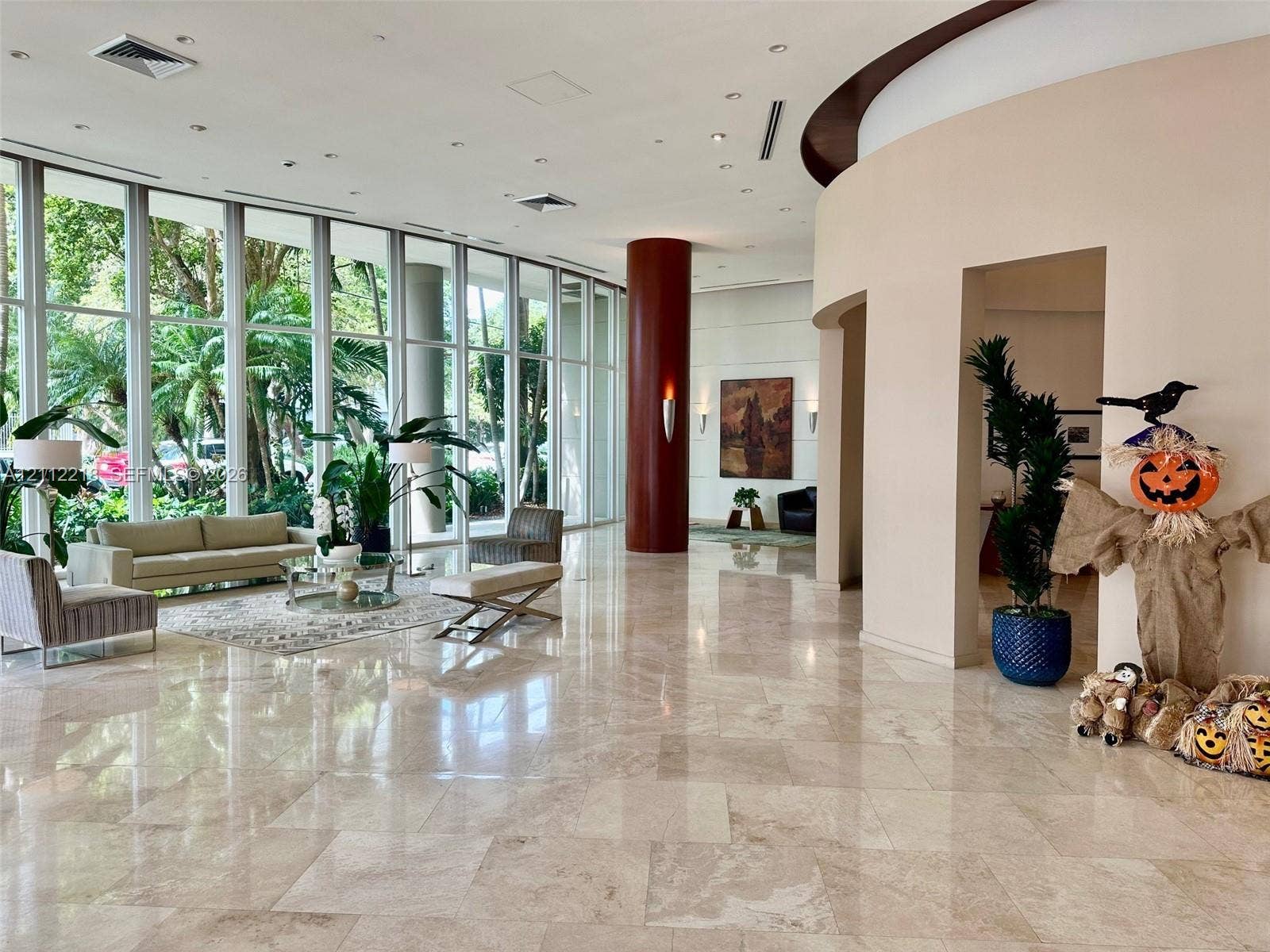 2475 Brickell Avenue, #1905, Miami, Miami, FL 33129 Expansive lobby featuring floor-to-ceiling windows, polished stone flooring, a prominent cylindrical structural column, and recessed ceiling lighting