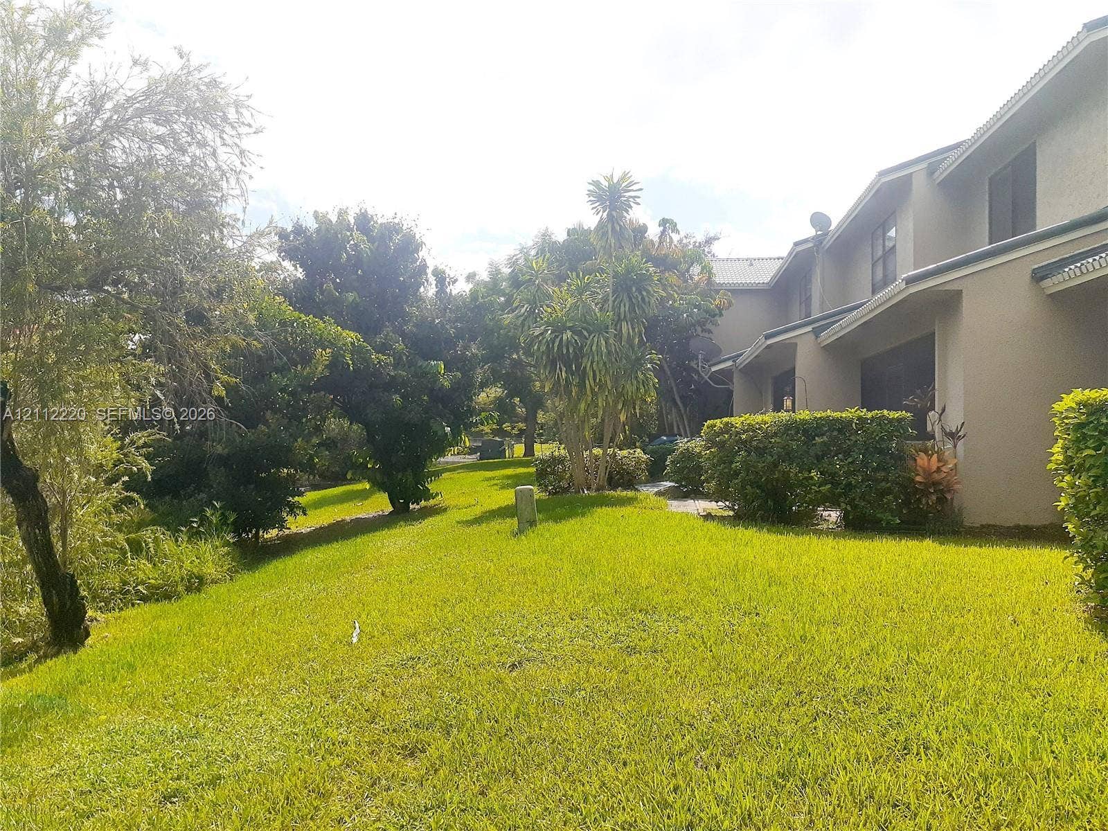 508 W Westree Lane, #508, Plantation, Plantation, FL 33324 Stucco exterior featuring sloped rooflines, multi-level construction, mature landscaping, and an expansive lawn