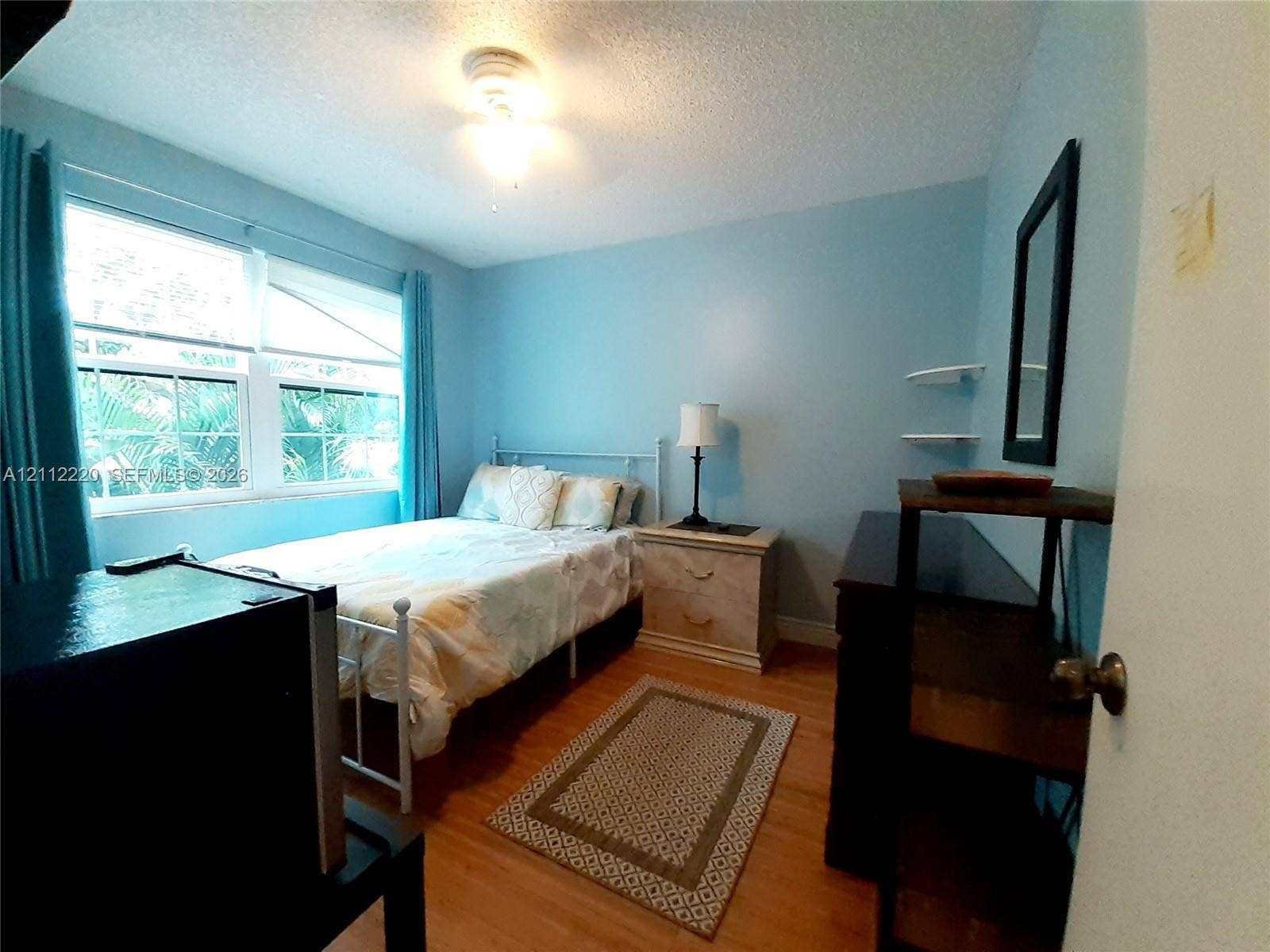 508 W Westree Lane, #508, Plantation, Plantation, FL 33324 Bedroom featuring wood-finish flooring, dual-pane windows, and wall-mounted shelving