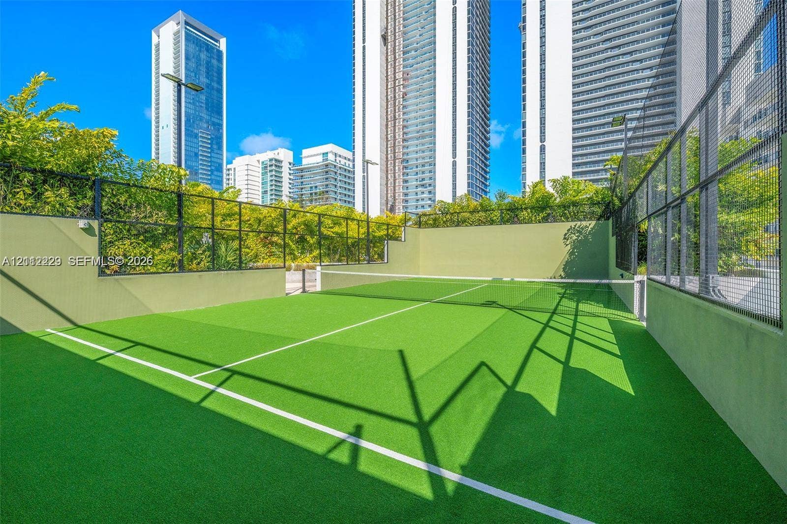 725 NE 24th Street, #706, Miami, Miami, FL 33137 Outdoor athletic court featuring synthetic turf surfacing, perimeter fencing, and concrete boundary walls