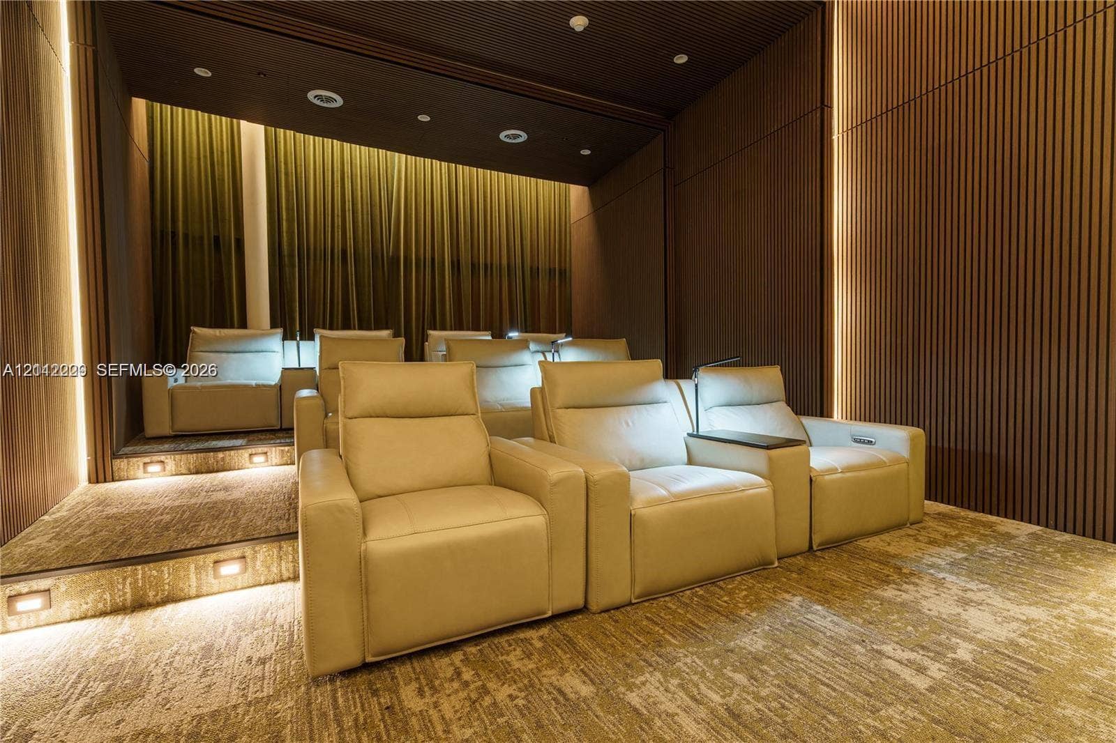 725 NE 24th Street, #706, Miami, Miami, FL 33137 Tiered theater room featuring custom vertical wood-slat wall paneling, integrated LED accent lighting, recessed ceiling lights, and integrated stair lighting