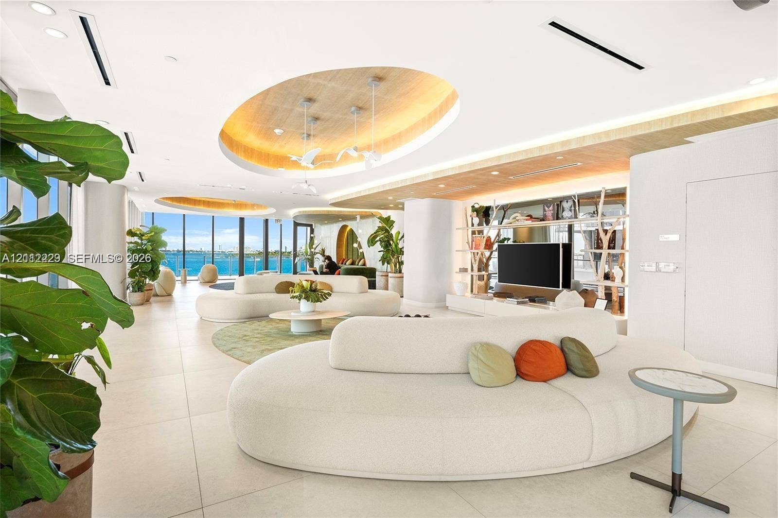 725 NE 24th Street, #706, Miami, Miami, FL 33137 Open-concept living space featuring tile flooring, recessed oval tray ceilings with warm lighting, floor-to-ceiling windows, and built-in shelving with integrated lighting