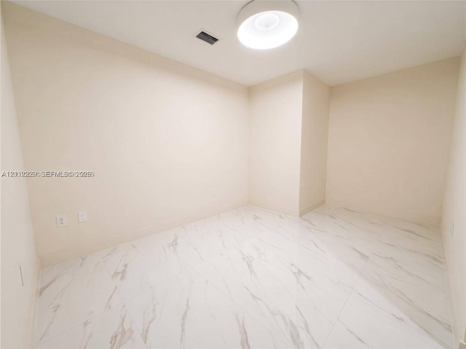 725 NE 24th Street, #706, Miami, Miami, FL 33137 Den featuring large-format white stone-finish tile flooring and a neutral color palette, illuminated by a contemporary circular flush-mount ceiling light