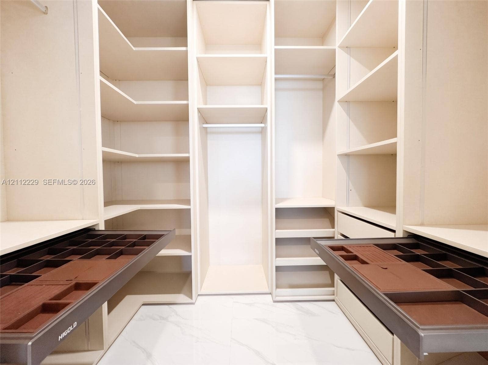 725 NE 24th Street, #706, Miami, Miami, FL 33137 Customized closet storage featuring floor-to-ceiling cabinetry, adjustable shelving, hanging rods, and integrated pull-out velvet-lined jewelry organizer drawers