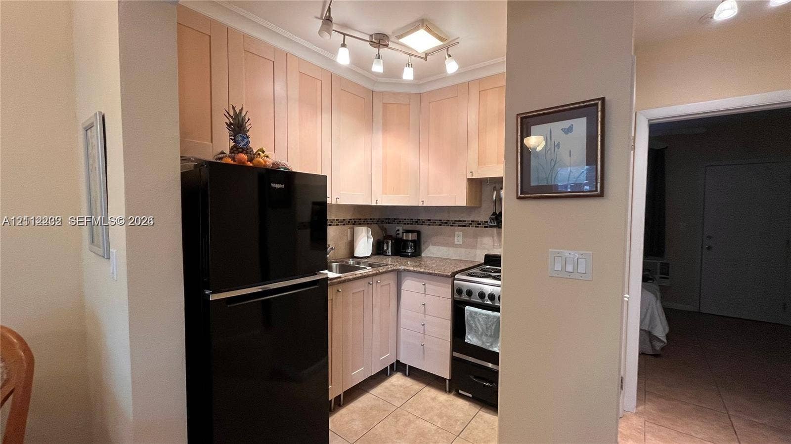 2001 S Ocean Drive, #55, Hallandale Beach, Hallandale Beach, FL 33009 Kitchen featuring light-toned cabinetry, stone-finish countertops, tile flooring, and track lighting