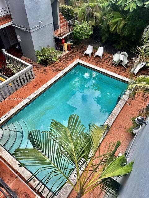 820 Salzedo Street, #305, Coral Gables, FL 33134 In-ground swimming pool featuring tiered stairs, stone coping, and a surrounding clay-tile patio deck