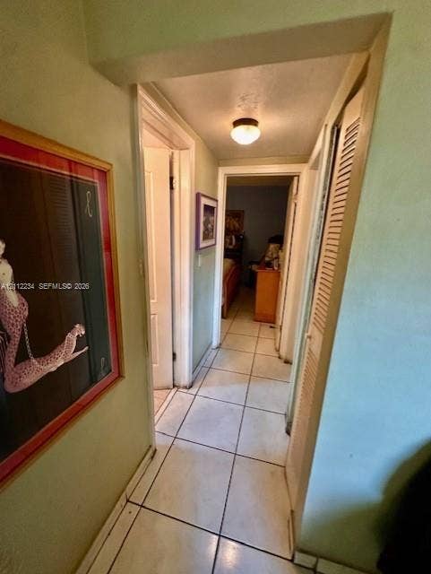 820 Salzedo Street, #305, Coral Gables, FL 33134 Hallway featuring neutral-toned tile flooring, flush-mount lighting, and louvered closet doors
