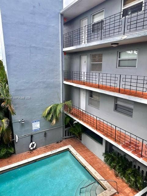 820 Salzedo Street, #305, Coral Gables, FL 33134 Exterior featuring a swimming pool with integrated stairs, terracotta-tiled patio, and multi-level balconies with decorative metal railings