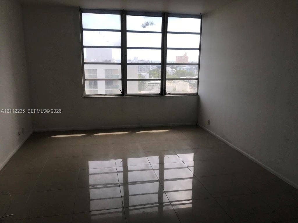 Large-format tile flooring and expansive multi-pane windows providing natural light