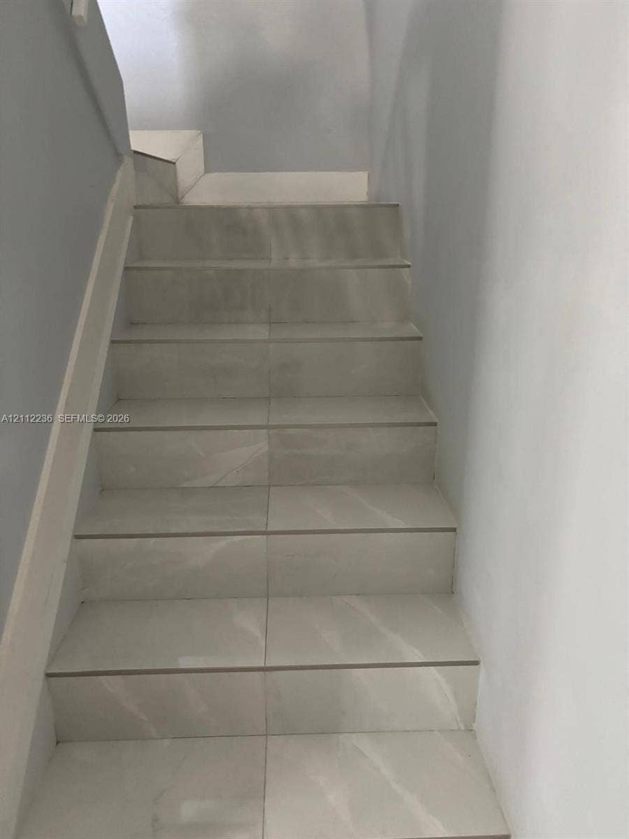 13946 SW 276th Street, #0, Homestead, FL 33032 Staircase finished with large-format light-toned tile featuring subtle veining, complemented by smooth painted walls