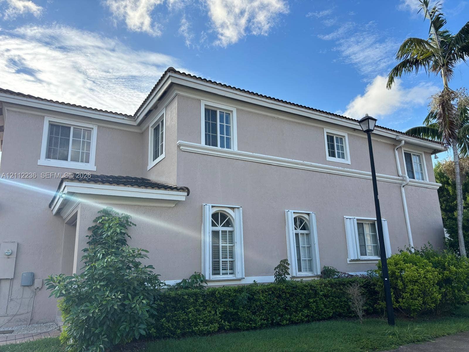13946 SW 276th Street, #0, Homestead, FL 33032 Two-story stucco exterior featuring arched windows, multi-pane glass, tiled roofline, and manicured landscaping