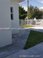 260 NW 40th Street, #S, Miami, Miami, FL 33127 Exterior featuring concrete paved walkway, manicured lawn area, white metal railing, and white perimeter fencing