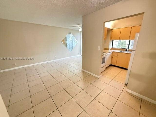 17011 N Bay Road, #415, Sunny Isles Beach, Sunny Isles Beach, FL 33160 Neutral-toned ceramic tile flooring, kitchen featuring light-toned cabinetry and a window, and wall-mounted diamond-shaped mirror