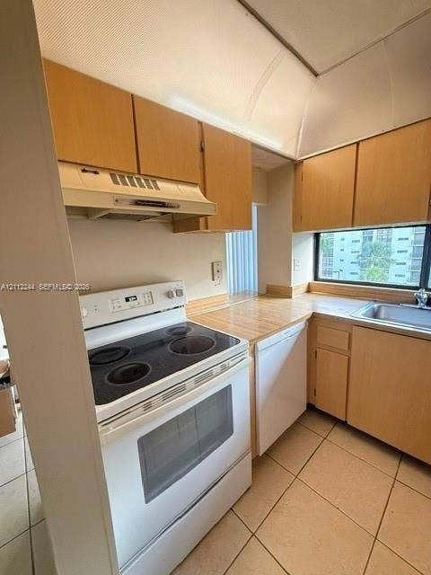 17011 N Bay Road, #415, Sunny Isles Beach, Sunny Isles Beach, FL 33160 Kitchen featuring wood-finish cabinetry, solid-surface countertops, tile flooring, and integrated white appliances including an electric range and dishwasher