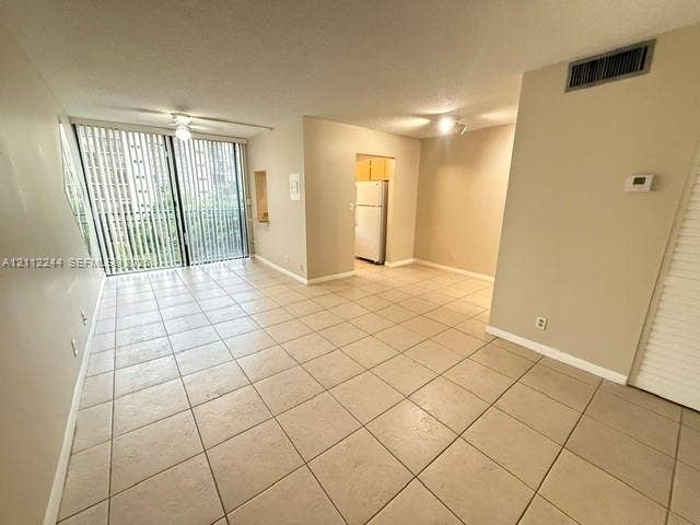 17011 N Bay Road, #415, Sunny Isles Beach, Sunny Isles Beach, FL 33160 Open interior featuring neutral tile flooring, sliding glass doors with vertical blinds, and a built-in wall niche