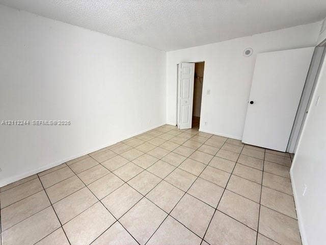 17011 N Bay Road, #415, Sunny Isles Beach, Sunny Isles Beach, FL 33160 Neutral-toned floor tiling, textured ceiling, solid core swing door, and bifold closet door