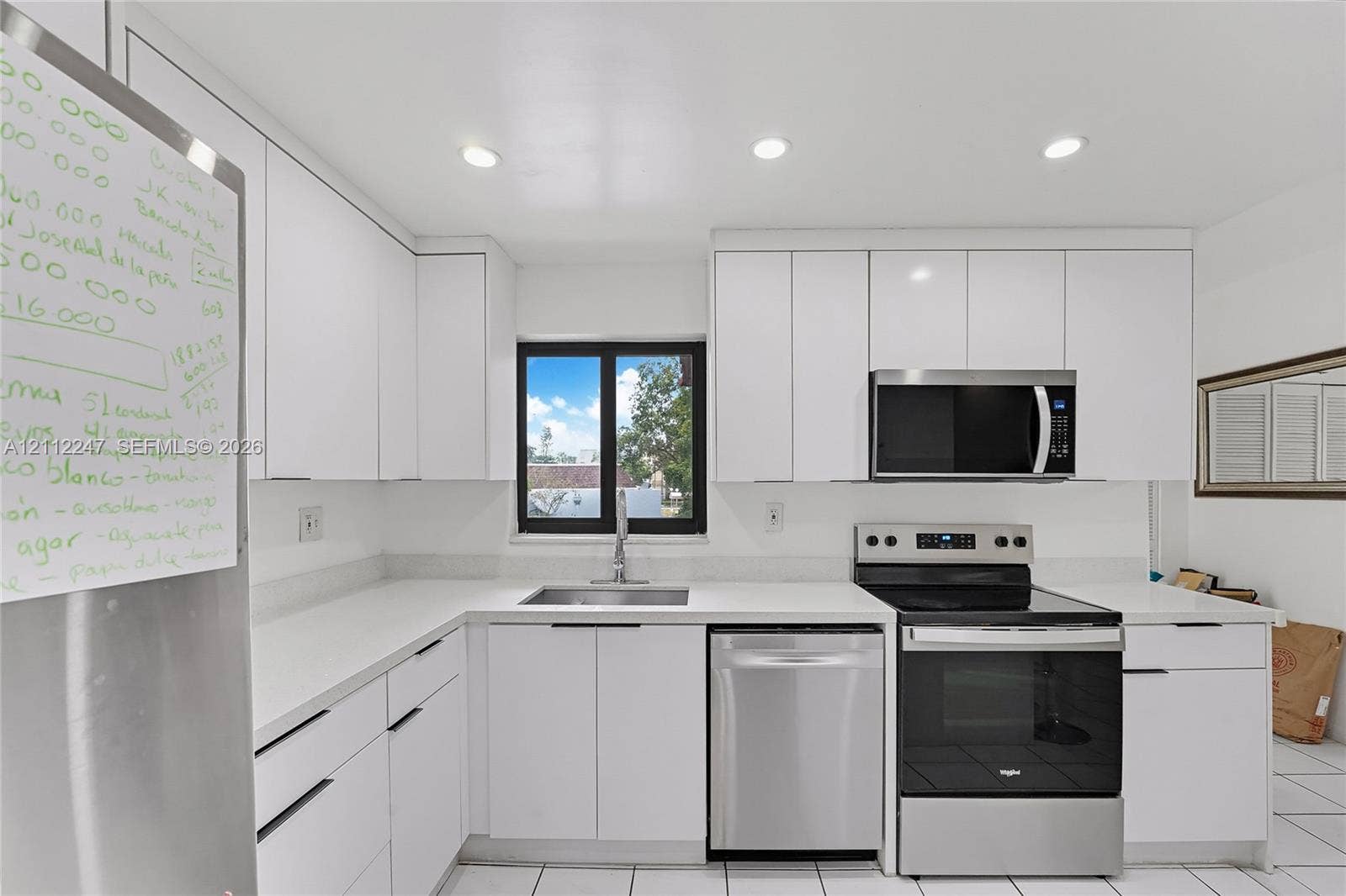 Kitchen featuring white slab-front cabinetry, stone-finish countertops, stainless steel appliances, and recessed lighting