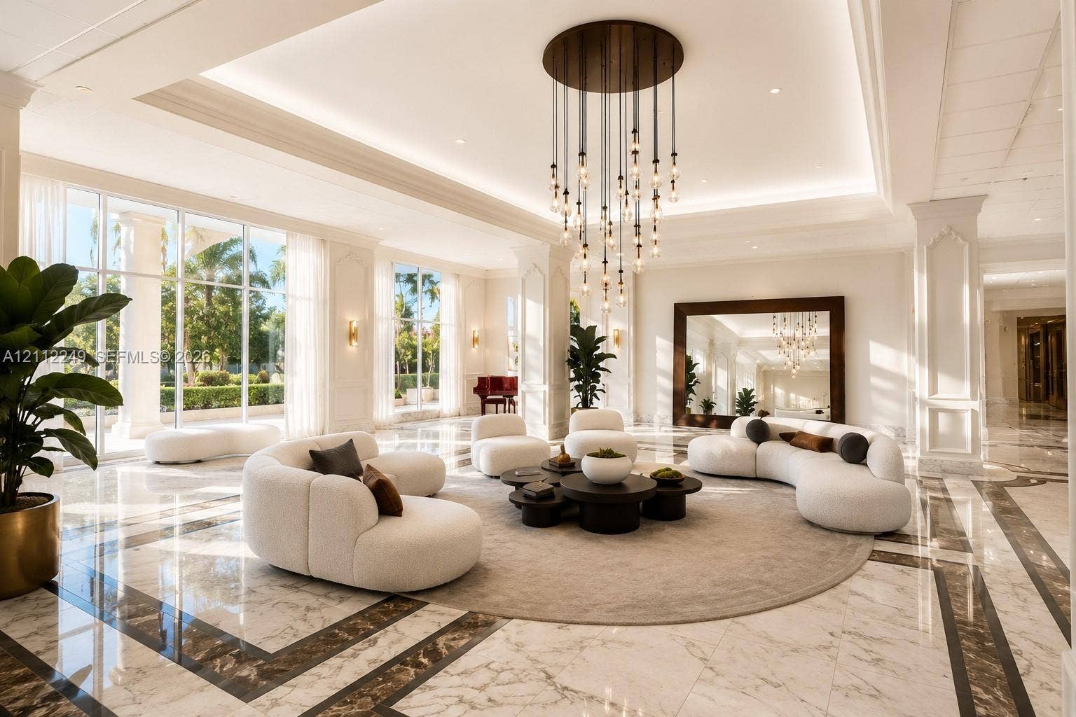 Grand lobby featuring polished stone flooring with intricate inlaid borders, floor-to-ceiling windows, tiered modern pendant lighting, and recessed ceiling coffers
