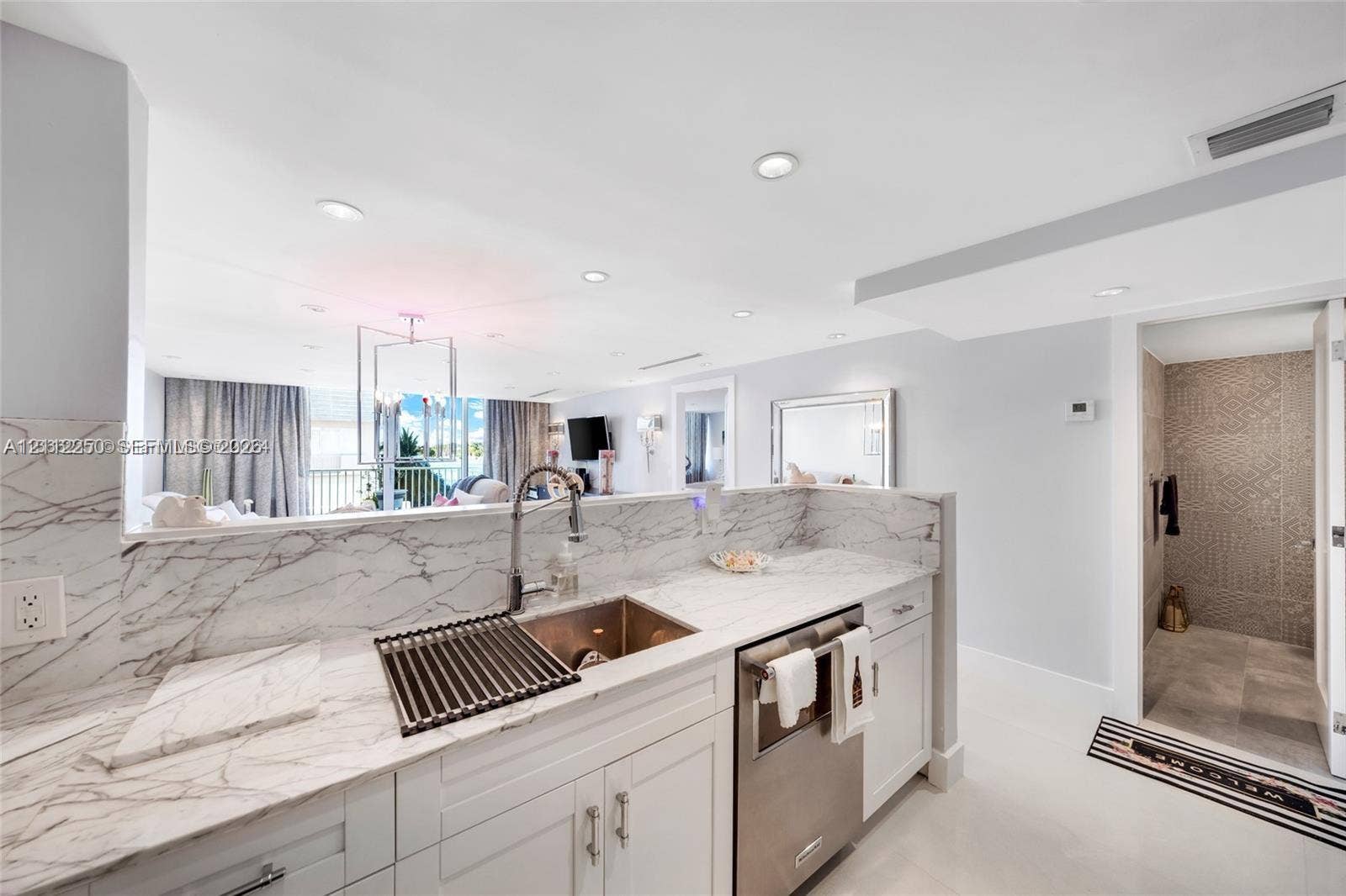 5838 Collins Avenue, #2F, Miami Beach, FL 33140 Kitchen featuring stone-patterned countertops, white cabinetry, a stainless steel undermount sink with a gooseneck faucet, and recessed lighting