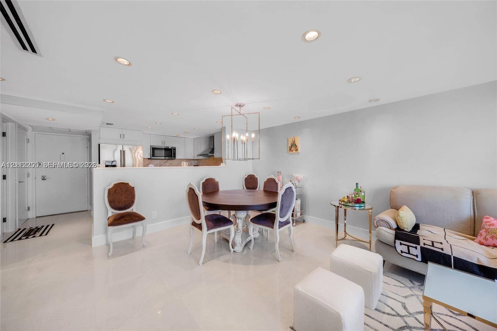 5838 Collins Avenue, #2F, Miami Beach, FL 33140 Open concept interior featuring polished stone flooring, recessed lighting, and a geometric multi-light metal pendant fixture