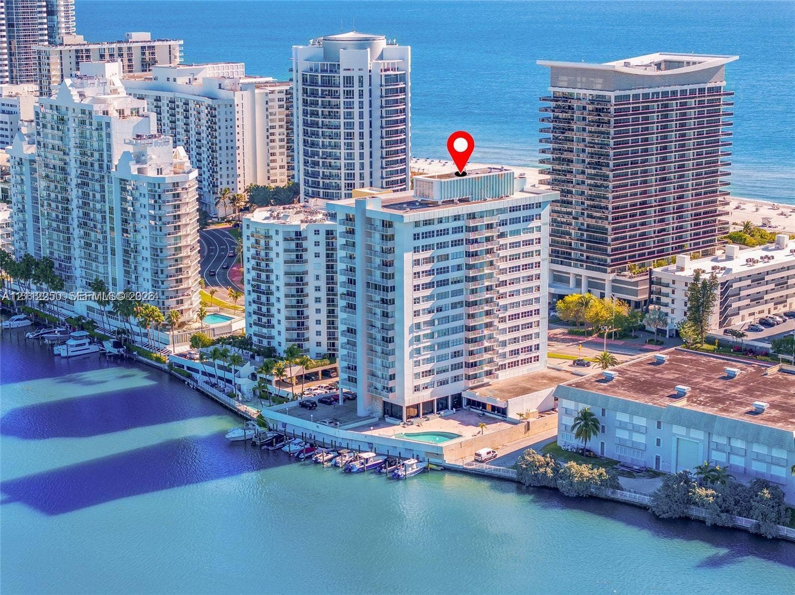 5838 Collins Avenue, #2F, Miami Beach, FL 33140 High-rise condominium featuring a waterfront location, private boat slips, an outdoor swimming pool, and coastal proximity