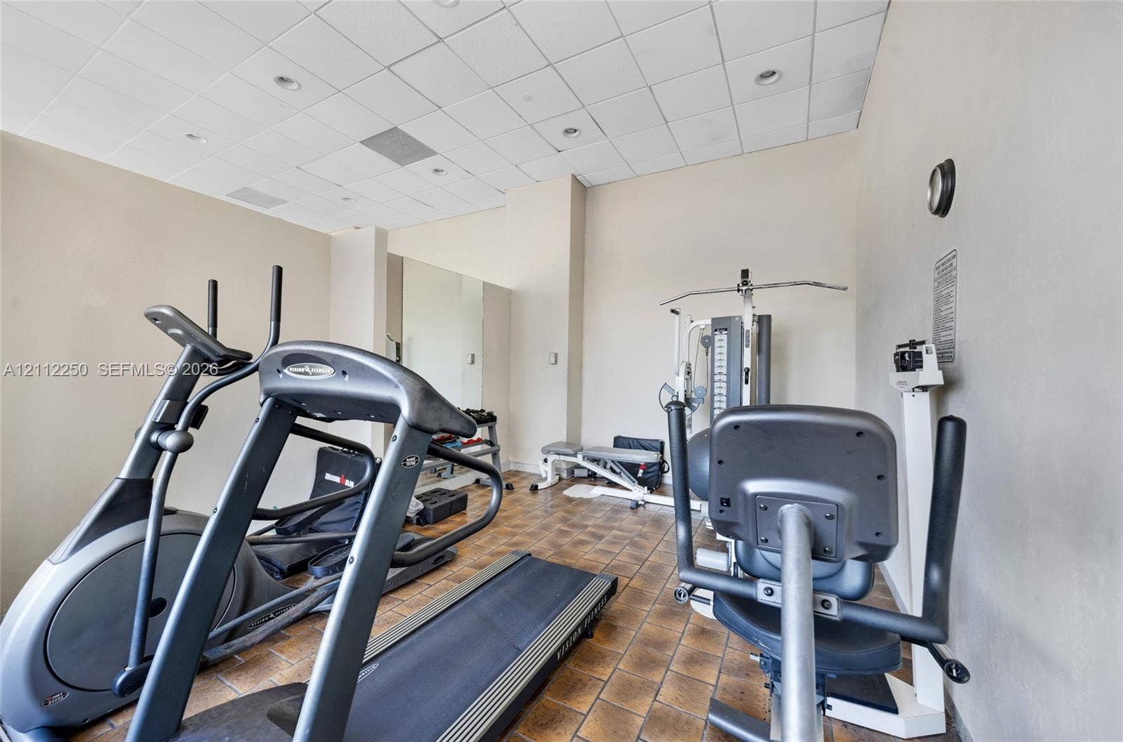 5838 Collins Avenue, #2F, Miami Beach, FL 33140 Fitness space featuring ceramic tile flooring, recessed ceiling lighting, drop ceiling panels, and wall-mounted mirror