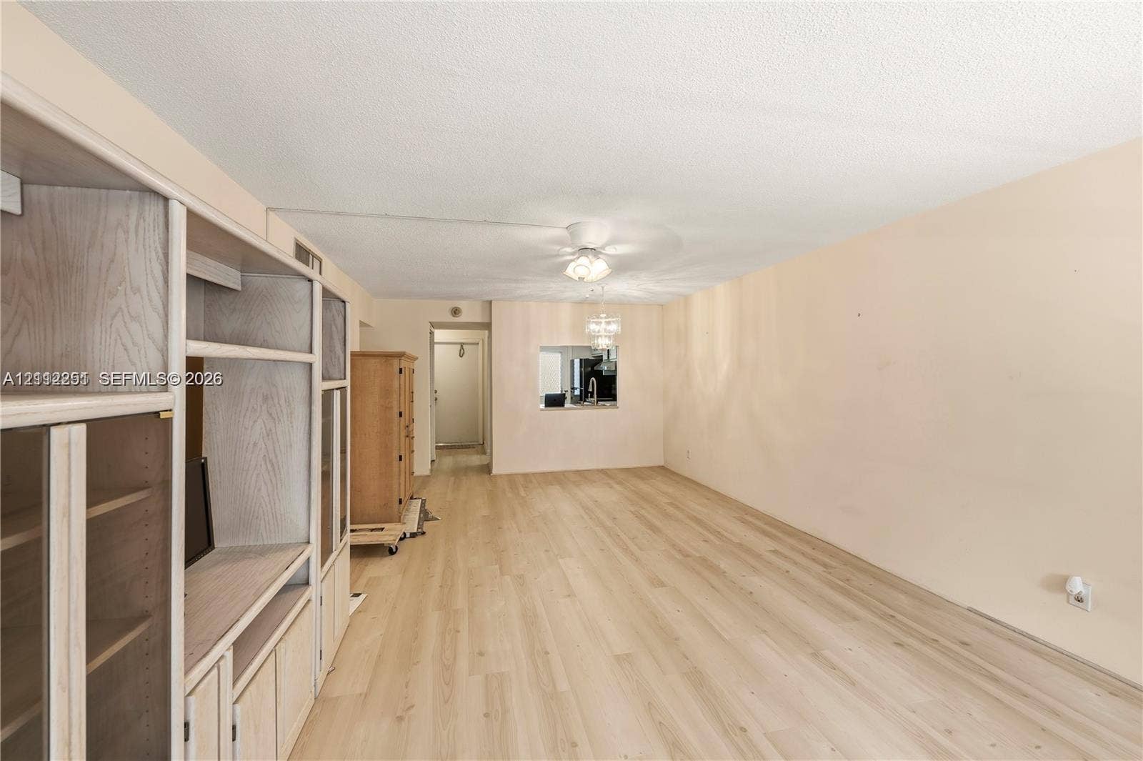 4025 N Federal Highway, #226C, Oakland Park, FL 33308 Light-toned wood-finish flooring, built-in floor-to-ceiling cabinetry, recessed ceiling fan with integrated lighting, and a pass-through window opening