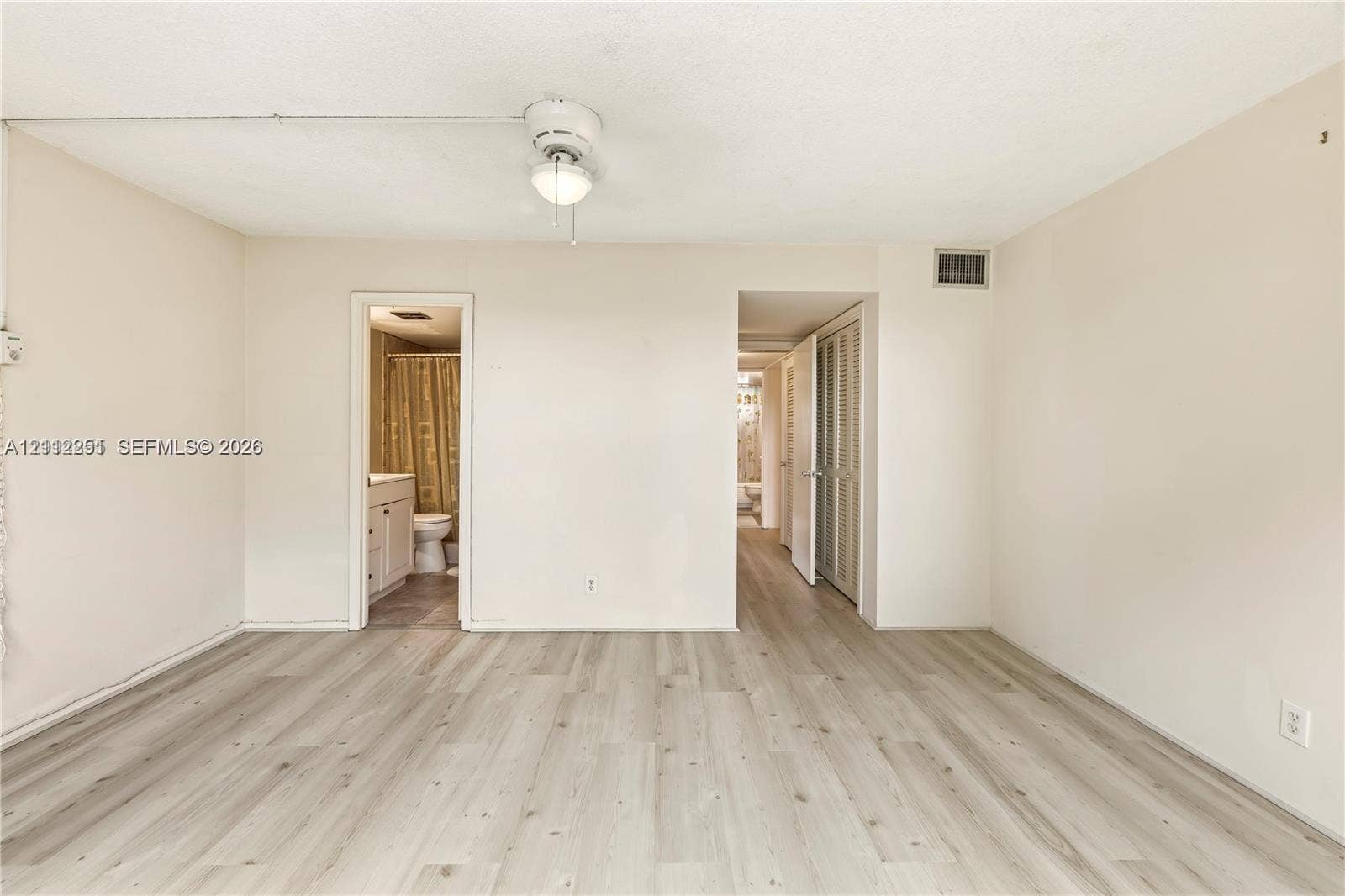 4025 N Federal Highway, #226C, Oakland Park, FL 33308 Interior room featuring wood-finish flooring, a ceiling-mounted light fixture with a fan, and bi-fold closet doors