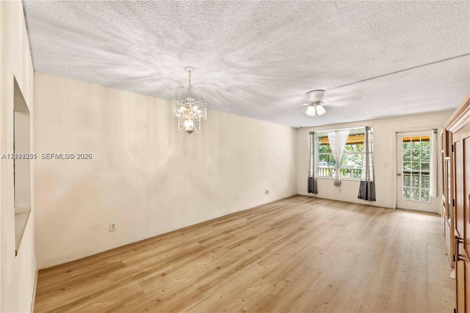 4025 N Federal Highway, #226C, Oakland Park, FL 33308 Interior space featuring wood-finish flooring, a decorative metal chandelier, a ceiling fan, and a glass-paneled exterior door