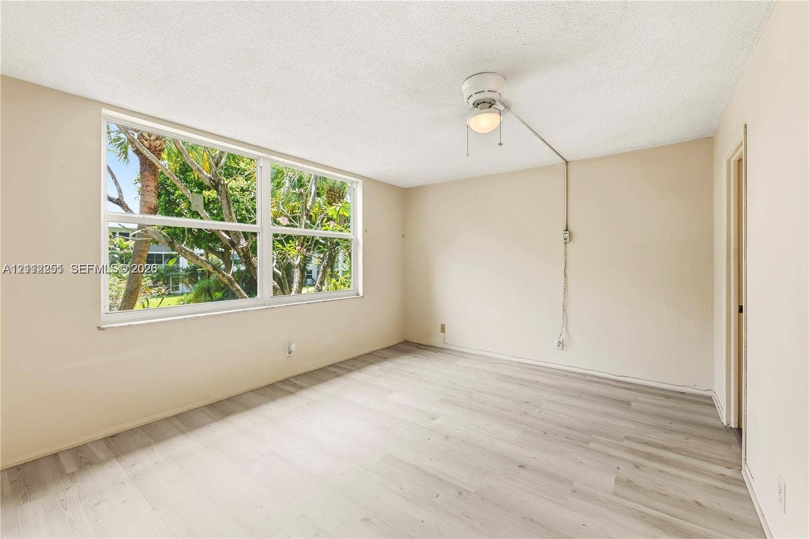 4025 N Federal Highway, #226C, Oakland Park, FL 33308 Room with wood-finish flooring, neutral walls, large window with natural light, and ceiling fan with integrated light fixture