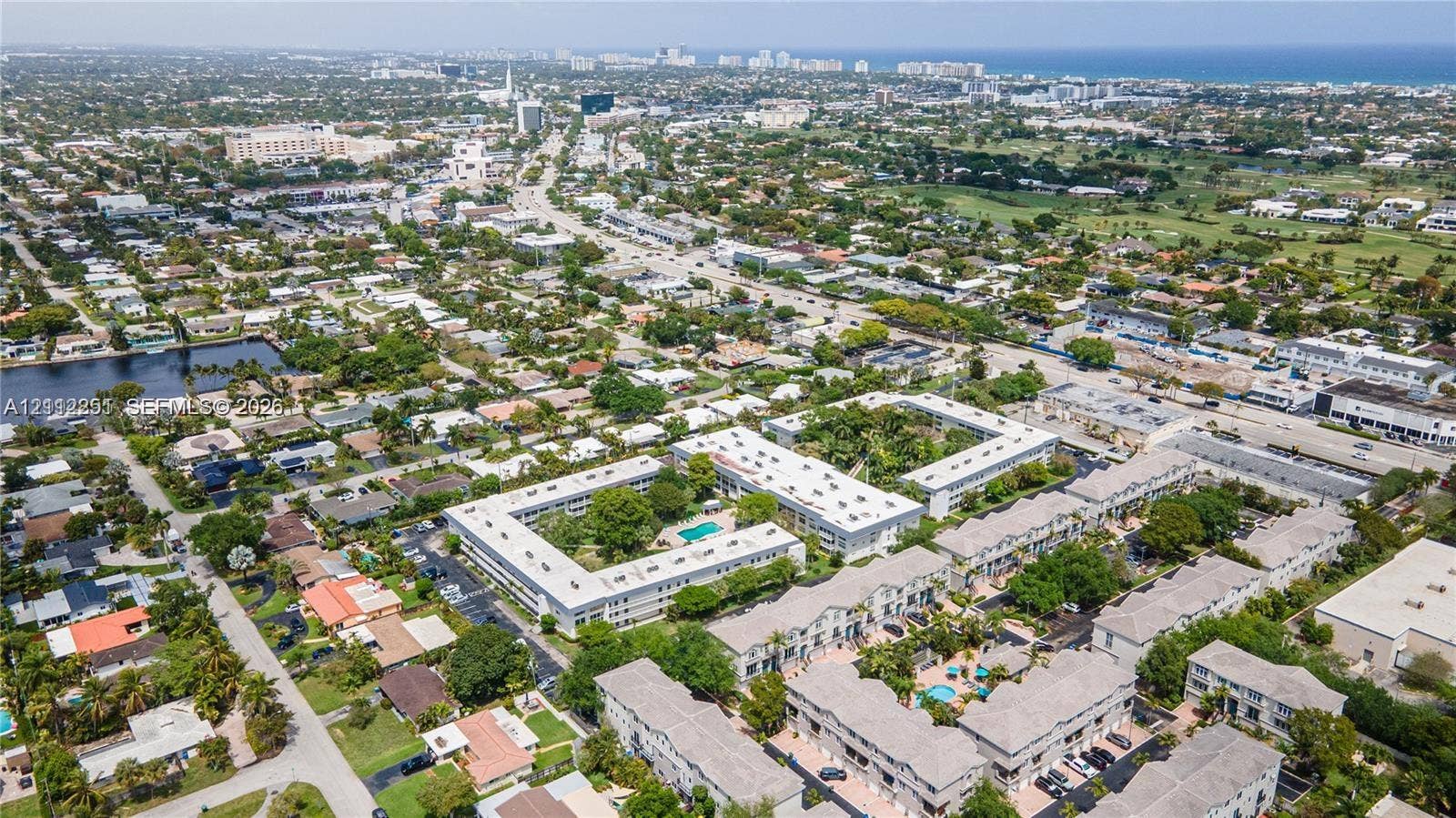 4025 N Federal Highway, #226C, Oakland Park, FL 33308 Aerial perspective of a multi-building residential complex featuring courtyards, swimming pools, and mature landscaping, situated within a coastal urban environment